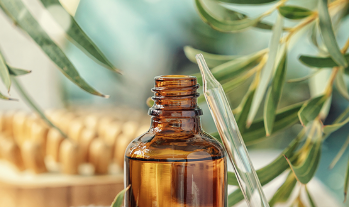 Amber glass bottle with dropper cap surrounded by fresh rosemary sprigs and natural materials.
