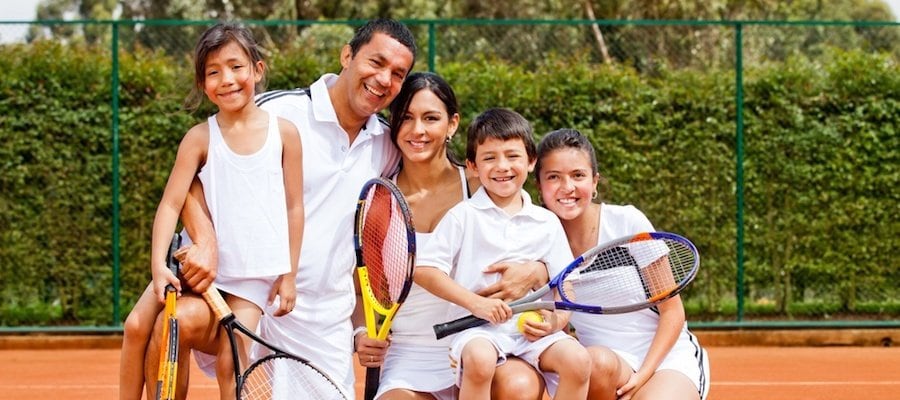 Happy family playing tennis