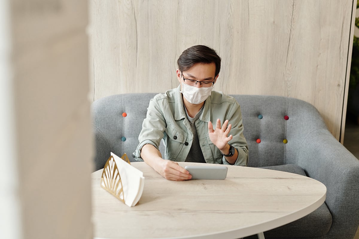 man-wearing-a-face-mask-having-a-video-call-4031817