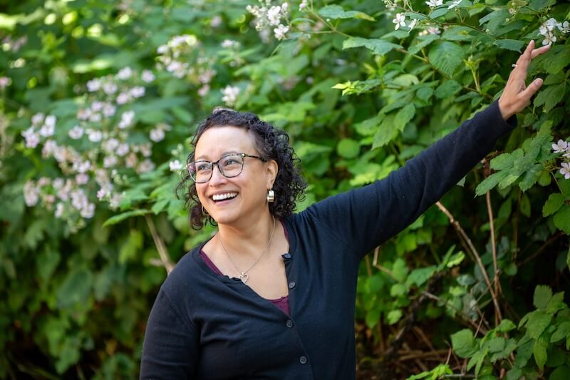Dr. Judith Thompson pointing at a bush sustainability