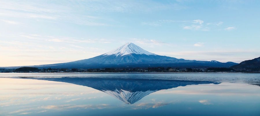 image of a snow-capped mountain being reflected in the water below it