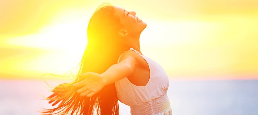 free happy woman enjoying sunset beautiful woman in a white dress embracing the golden sunshine glow of sunset with her arms outspread and face raised to the sky enjoying peace and serenity of nature