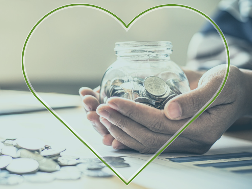 Hands holding a glass jar of coins surrounded by a green heart