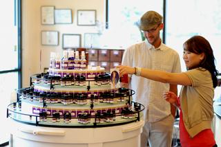 two people look at essential oil bottles in a retail shop