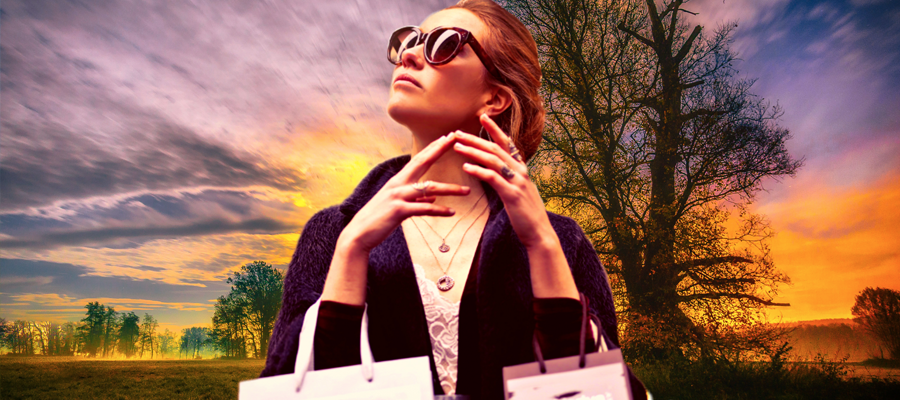 a woman wearing sunglasses and holding two shopping bags on her arms looks up while standing in a field with trees