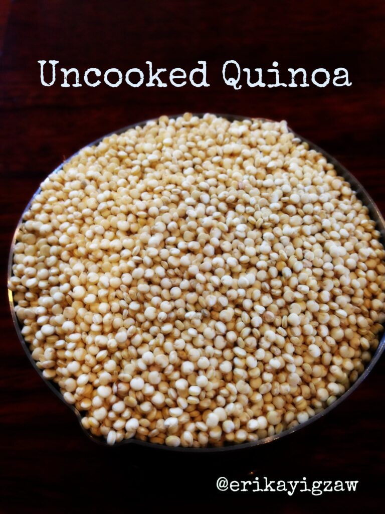 a pile of uncooked quinoa on a black surface