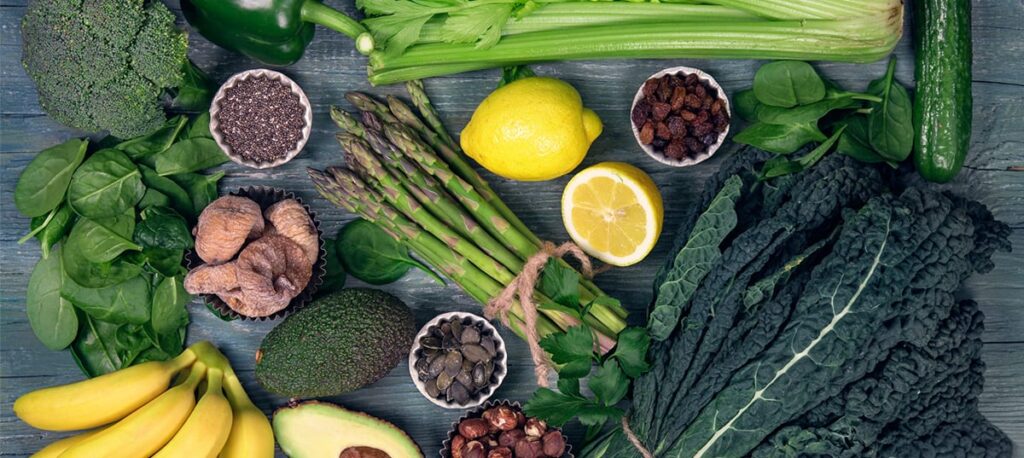 overhead shot of fruits and veggies laid out on a wooden table