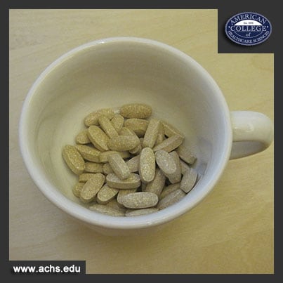 shot of a white mug from above, the mug is holding a few dozen small brown pills speckled with white