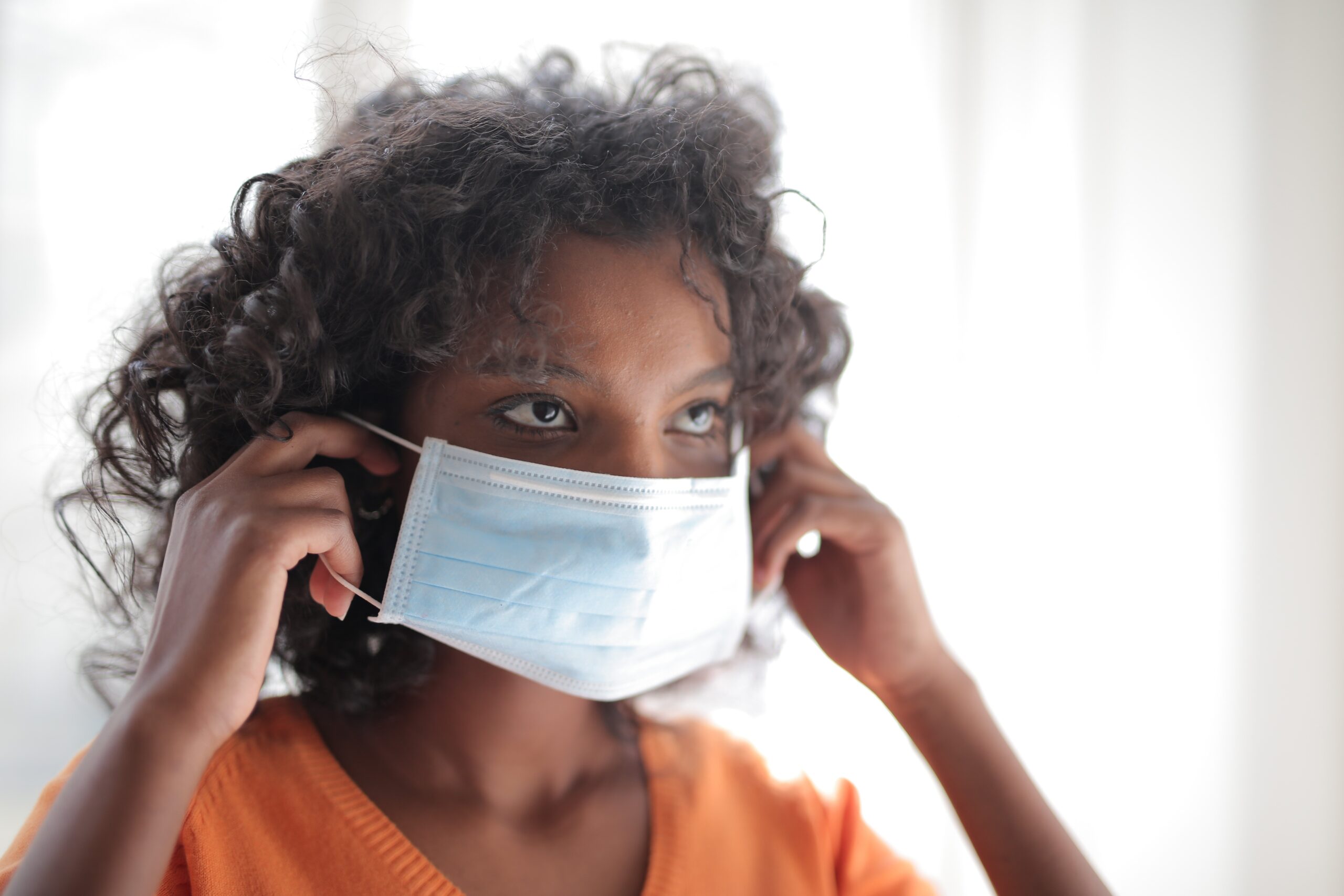 woman-in-orange-crew-neck-shirt-wearing-white-face-mask-3961062