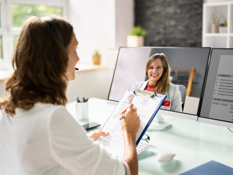 A woman interviews an internship candidate on a computer