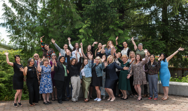ACHS Staff and faculty pose for a group photo with their hands in the air