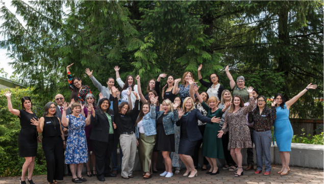 A group photo of ACHS faculty and staff with their hands in the air