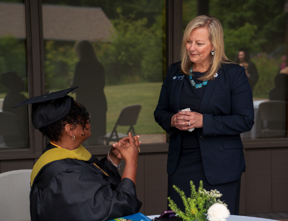 Tracey Abell speaks with a graduate at ACHS Commencement