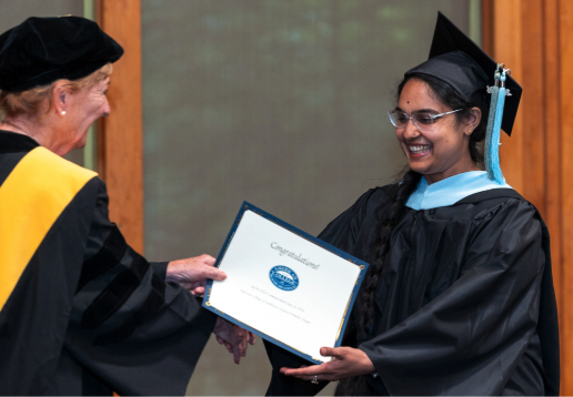Dr. Janet Ludwig presents a degree to an ACHS graduate