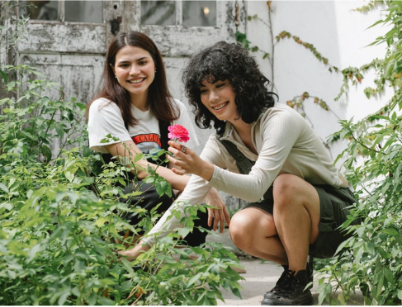 Two women work in a green herb garden