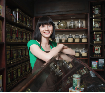 A woman stands behind a counter at a retail store