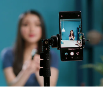 An influencer filming herself with a phone on a stand