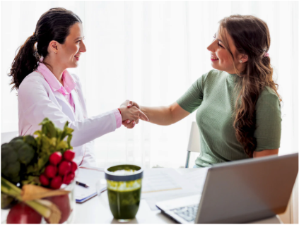 A nutritionist shakes hands with a client