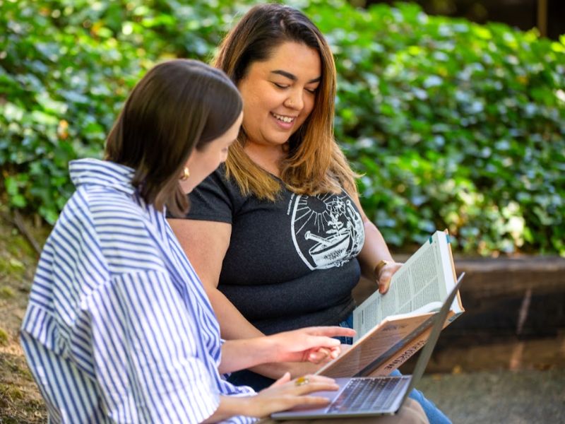 Two women looking at a textbook