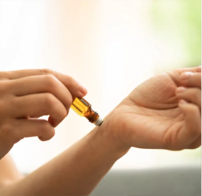 An essential oil roll on being applied to the wrist