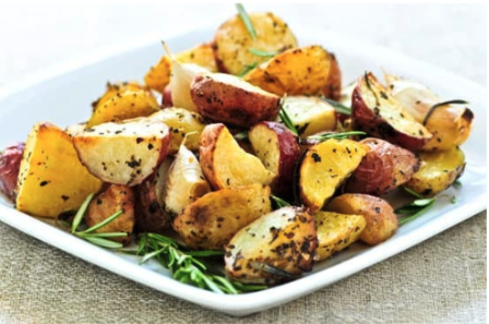 A plate of cooked potatoes with the skin left on