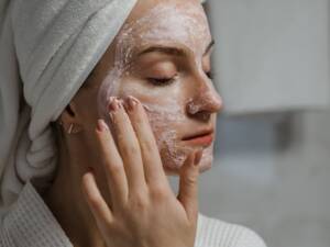 A woman putting an herbal face mask on
