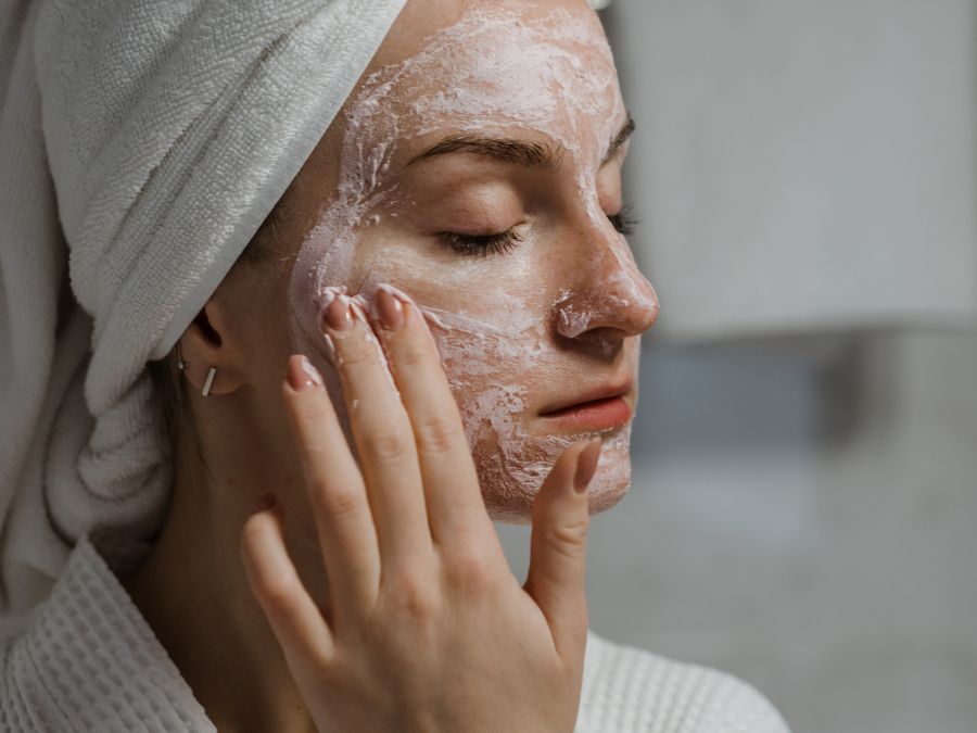 A woman putting an herbal face mask on
