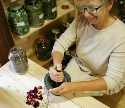 A woman grinding herbs with a mortar and pestle