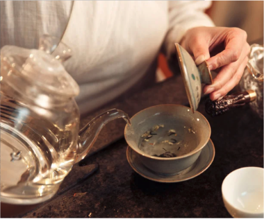 pouring herbal tea into a mug
