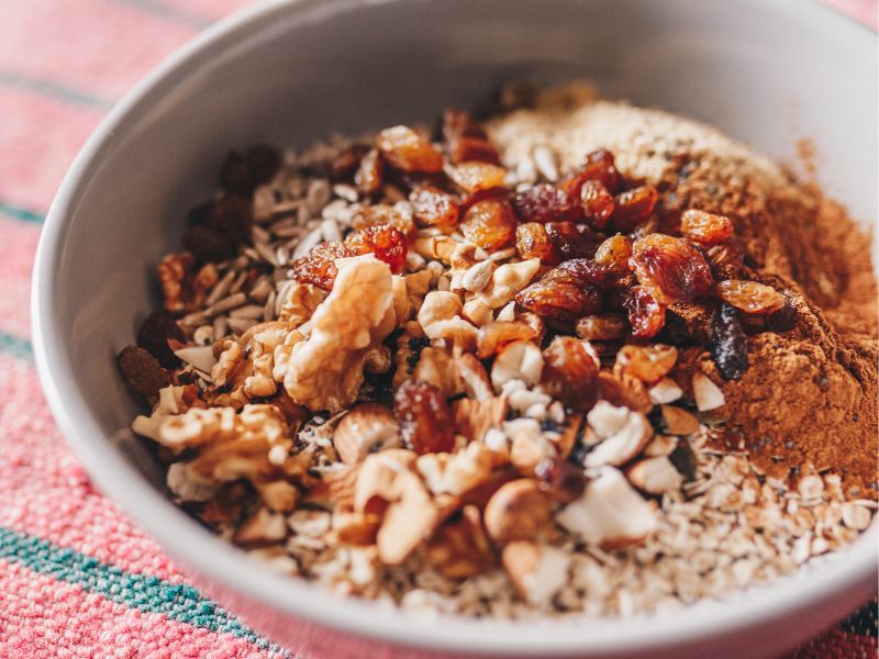 A bowl of steel-cut oats with buts and cimnnamon