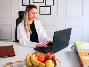 A wellness professional working at a desk with a laptop