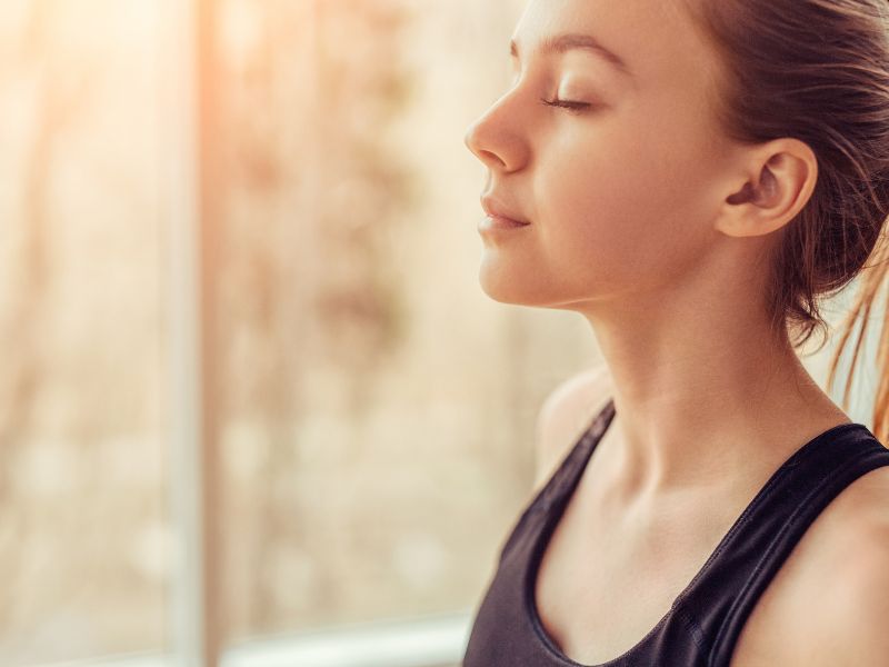 A woman breathing deeply through her nose