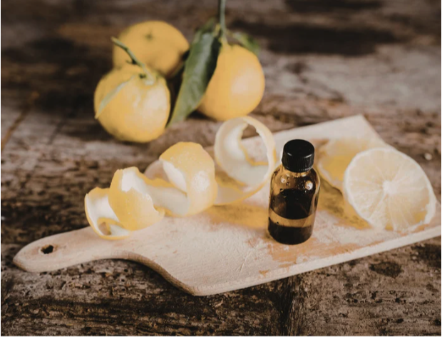 Citrus essential oil bottle next to lemons on a cutting board