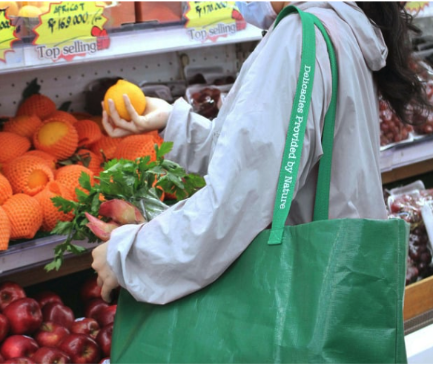 A person selecting produce at a grocery store