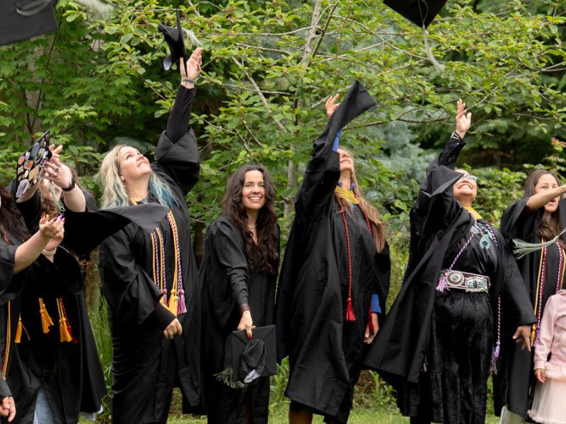 ACHS graduates throwing their tams in the air in celebration