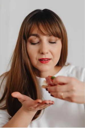 a woman eating food with her hands