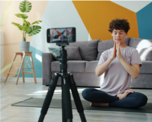1. A woman sits in a yoga pose with her hands raised, embodying tranquility and focus in a serene environment.