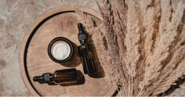amber essential oil bottles and a container of skin cream