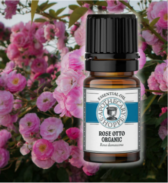 A bottle of Rose otto essential oil on a background of pink roses 