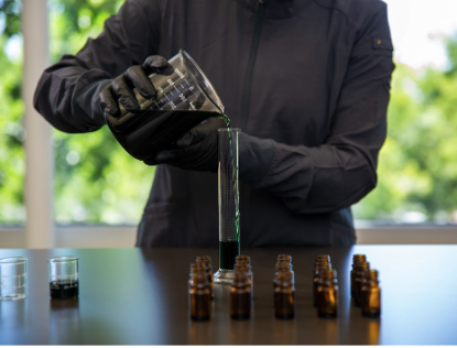 A production worker measure essential oil into test tubes
