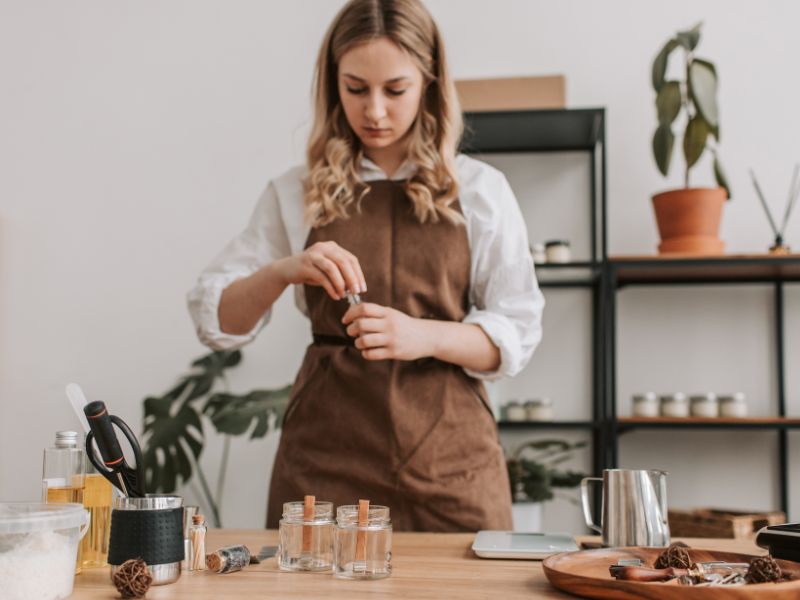A woman in an apron making natural products