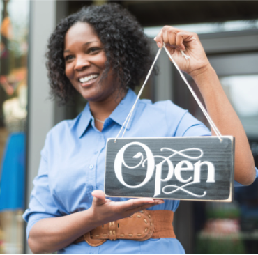 Woman holding open sign
