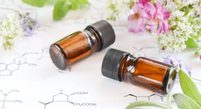 two brown bottles lie on a table surrounded by small pink and white flowers