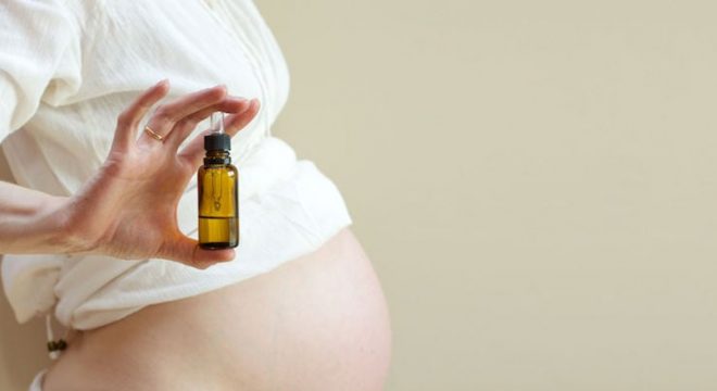 46974590 - a dropper bottle of essential oil in the hand of pregnant woman