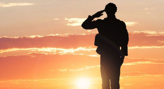 56931439 - silhouette of a soldier saluting during sunset