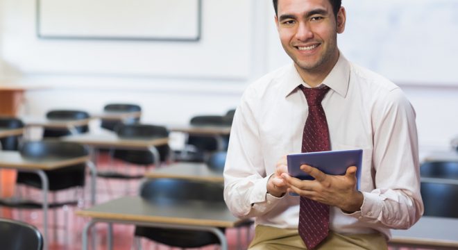 Portrait-of-a-smiling-teacher-with-tablet-PC-in-the-class-room