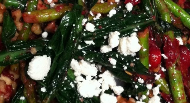 a close up shot of roasted veggies with feta on top of it