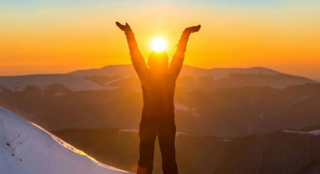 39704535 - woman on the top of winter mountain holding sun in her hands